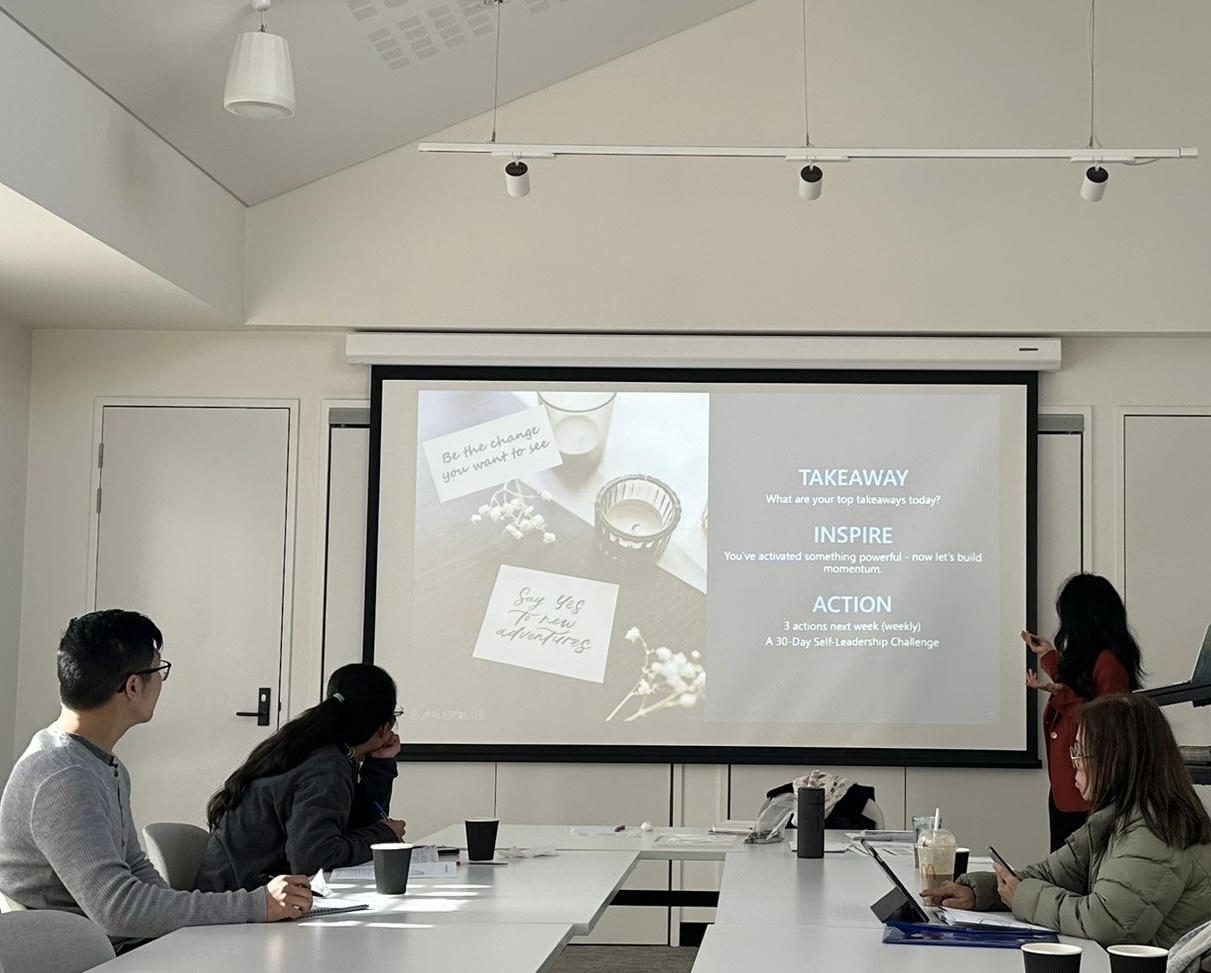 Thu Anh Flynn presenting the Activate Your Inner Leader workshop to a small group around a table